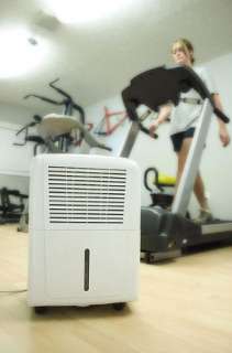 Dehumidifier cools gym while woman runs on treadmill