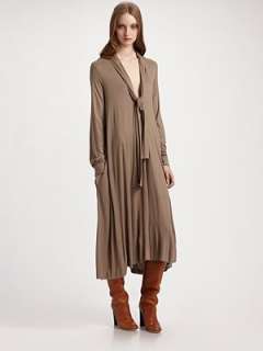 Deep V neckline Attached scarf Long sleeves with button cuffs Full cut 